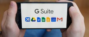person holding up a smart phone with the word g suite on it